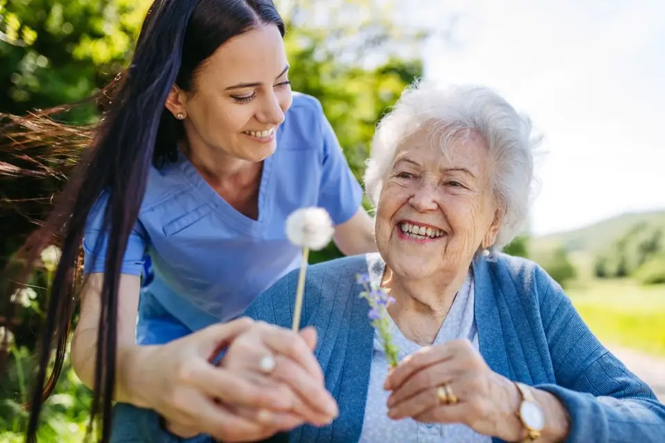 Caregiver sharing a warm moment outdoors with a smiling resident